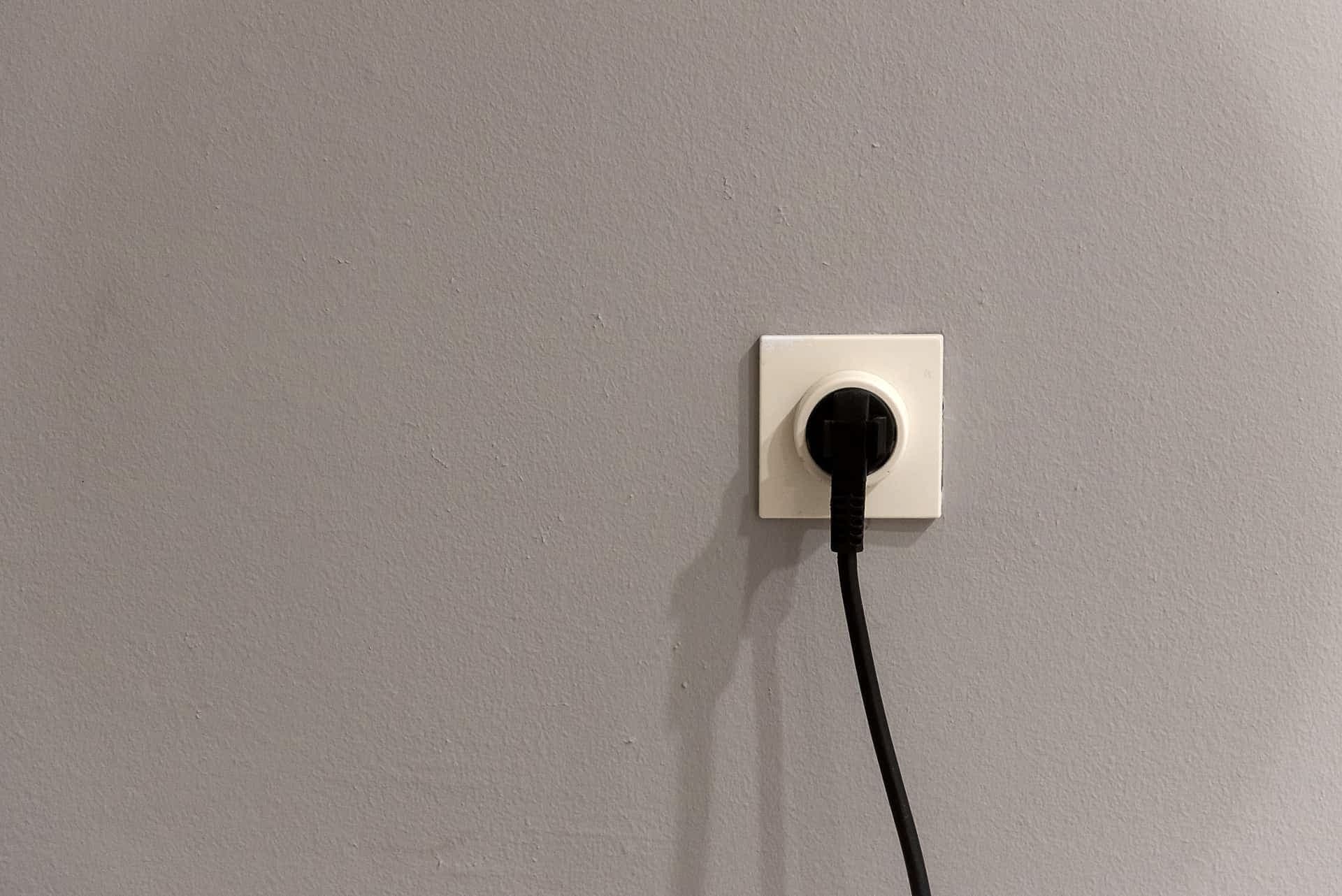 A power plug being inserted into a wall socket